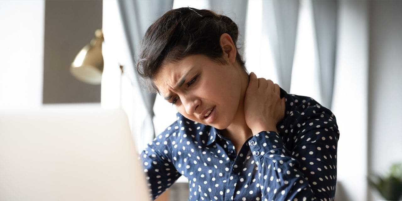 woman in pain, touching or pressing the back of her neck, indicating fibromyalgia