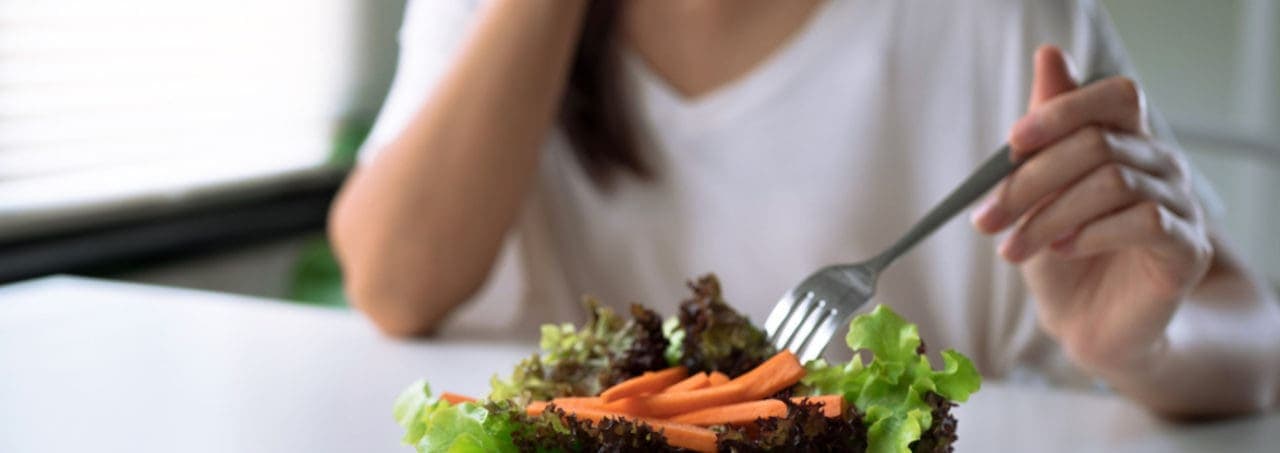 A woman pushing away a salad